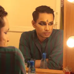 A candid moment in the green room, with the character's makeup on, but the performer's thoughts within.