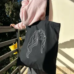 Simple, elegant, and modern. This black tote features a minimalist line art design, making it a versatile accessory that pairs well with any casual look.