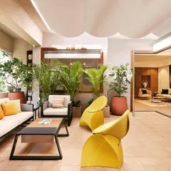 This image showcases the contrasting design aesthetics of the two neighboring apartments we designed, one with a bright, eclectic, and plant-filled living area.