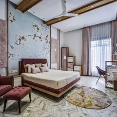 I love the soft, romantic feel of this bedroom. The floral wallpaper accent wall adds a touch of artistry, while the mix of textures in the rug, armchair, and bedding creates a cozy and inviting atmosphere.