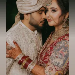 An intimate close up of the bride and groom. Her intricate henna, the rich red of her bangles, and their gentle embrace tell a story of love and tradition.
