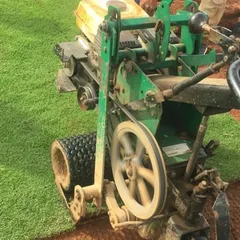 A specialized machine used to harvest the grass from my farm, ensuring each roll is cut to a uniform thickness.