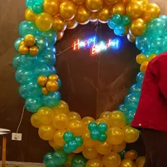 A close-up of our popular ring decoration. This one, in teal and gold, is a great backdrop for photos. We added a 'Happy Birthday' neon sign in the center to complete the look for this office celebration.