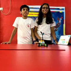 Two students collaborate on a robotics project, working together to program their LEGO vehicle using a tablet. Our classes emphasize teamwork and peer learning to solve engineering challenges.