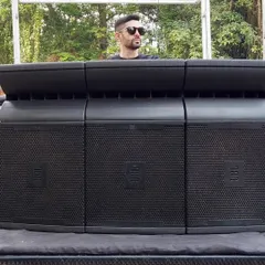 Standing behind a powerful sound system at an outdoor event. Delivering crisp, clear sound is crucial for any party, especially for a baraat or outdoor celebration where the music needs to carry.