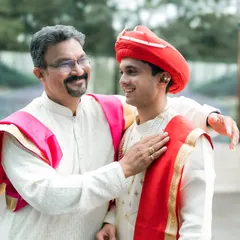 A proud father shares a happy moment with his son, the groom, just before the wedding ceremony.