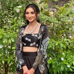 A full view of this modern, nature-inspired look. The makeup is minimal and elegant, letting the unique outfit be the star.