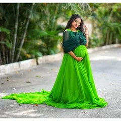 A beautiful shot of an expecting mother in a green trail gown. The long, flowing fabric adds a touch of magic to maternity photos.