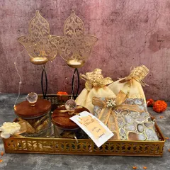I love creating hampers that feel personal and luxurious. This one, set on a golden tray, combines crystal-lid jars, elegant potlis, and two stunning leaf-design T-light holders, making it a complete festive gift.
