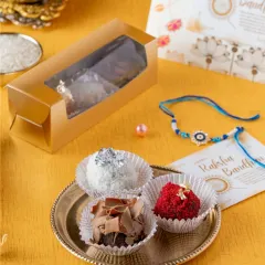 I've given the traditional laddoo a modern twist with my special brownie laddoos. This box contains Milkmaid brownies blended with white chocolate, red velvet, and ganache, shaped into laddoos for a fun Rakhi treat.
