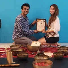 Another proud graduate of our Sound Healing Teacher Training, holding her certificate amidst the tools of her new craft.
