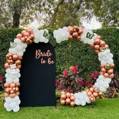 We created this elegant "Bride to be" backdrop for a garden party. A circular balloon arch in rose gold and white wraps around a custom black panel, creating a sophisticated and modern photo opportunity for the bride and her guests.