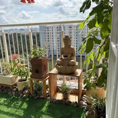 This view shows how all the elements come together: the Buddha statue for peace, the Tulsi plant for tradition, and flowering plants for a dash of colour, all overlooking the city.