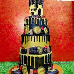 This massive three-tiered cake was for a golden 50th birthday. The black and gold theme exudes luxury, with chocolate drips, gold-dusted chocolates, and even mini cakesicles as part of the decoration.