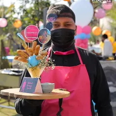 For a truly immersive experience, my staff and I embrace your event's theme. Here, one of my uniformed team members presents "Buttered Sausage Guards" at a Squid Game themed birthday, showcasing my commitment to creative, detailed event execution.