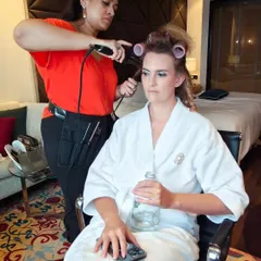 Getting a client ready for a big event. Here I am curling her hair, setting the foundation for a voluminous and glamorous hairstyle.