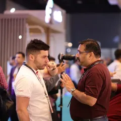 Two attendees in a deep conversation on the expo floor. These spontaneous interactions often lead to valuable insights and new professional relationships.
