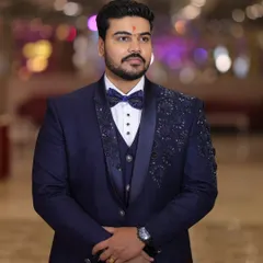 The complete look. A full portrait of a client wearing his hand crafted navy blue tuxedo, showcasing the perfect fit and the elegant silhouette for his special day.