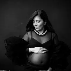A quiet, introspective moment. Black and white enhances the emotion, drawing your eye to her gentle expression and the delicate details of her top.