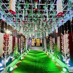 We created this enchanting passage for a Kali Puja event. The design features a ceiling of lush greenery with hanging red roses and traditional bells, creating a beautiful and devotional pathway for attendees.