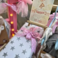 A personalized welcome card for baby Vannya, placed on a miniature easel, serves as a beautiful focal point in her grand welcome trousseau.