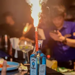 A bottle of Bombay Sapphire with a celebratory sparkler at the bar. This image captures the premium, high-energy party atmosphere that I strive to create at all my events.
