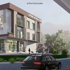 An angled view of the Divine Retreat Inn highlights its relationship with the surrounding environment. The design incorporates a modern entrance canopy and large ground-floor windows to create a transparent and inviting connection to the street.