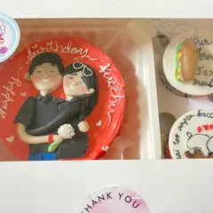 A close-up of one of our favourite bento and cupcake combos. This set features a hand-painted Nutella hazelnut bento cake with a couple's portrait, paired with cupcakes showing their inside jokes like "our forever 3 am meal".