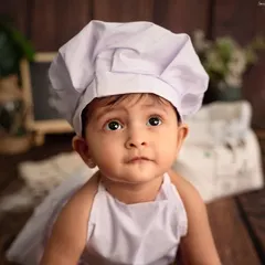 A close-up of our adorable little chef. Her curious eyes and sweet expression are the main ingredients in this heartwarming baby chef themed photoshoot.