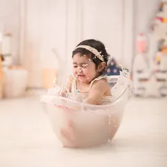 A candid action shot of a happy splash. Our milk bath photography sessions are full of these playful, unscripted moments.