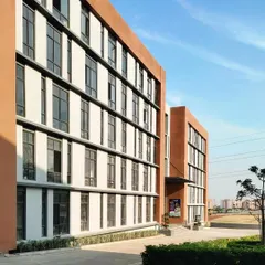The façade of Sage University, showcasing the rhythmic pattern of windows and the use of terracotta. The building's form and materials were chosen to be both modern and responsive to the local climate.