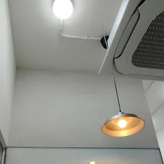 Another view of a textured wallpaper installation, showing clean work around lighting and an AC unit.