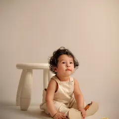 This six-month-old is full of curiosity. Our milestone sessions use minimalist props and neutral backgrounds to keep the focus entirely on your baby's development and personality.
