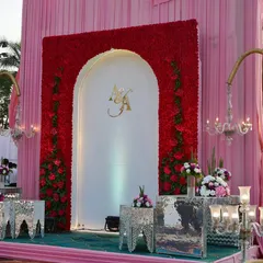 For a truly grand statement, we created this stunning stage backdrop featuring a massive red floral arch. The couple's custom gold monogram was placed in the center, making for a regal and personalized focal point.