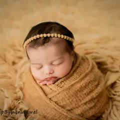 Wrapped in soft, earthy tones, this portrait highlights the serene beauty of a sleeping newborn. My focus is always on your baby's comfort, using safe wrapping techniques and simple, elegant props to create a peaceful and natural look.