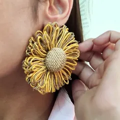 A close-up shot of me wearing the handcrafted jute flower statement earring, showing its scale and texture.