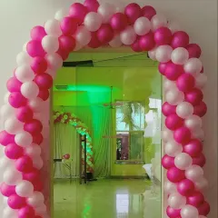 A simple yet elegant pink and white balloon arch at the entrance of a party hall. This classic design is perfect for birthdays, anniversaries, or baby showers.
