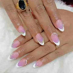 A matching manicure and pedicure set. This image shows the hand with a beautiful purple and white ombre design and rhinestone accents.