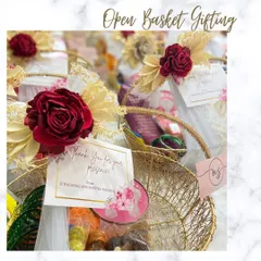 A beautiful open basket return favour for a housewarming, but perfect for a wedding too. The gold wire basket is adorned with a red rose and filled with traditional items.
