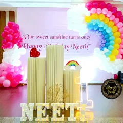 A "sweet sunshine" party for Neeti's first birthday, featuring a beautiful balloon rainbow and fluffy balloon clouds.