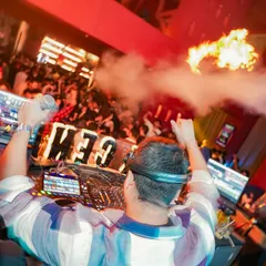 There's no feeling like being behind the decks, facing a sea of people, with the energy turned all the way up. This shot, with the pyrotechnics firing, captures the peak moment of a high-octane club night.