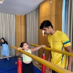 A coach provides hands-on assistance as a child learns to use the parallel bars. We prioritize safety and proper technique in all our gymnastics activities.