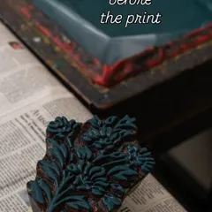 This is the quiet moment just before the art happens. A hand carved wooden block, inked and ready, rests on a newspaper, waiting to be pressed. It is a pause filled with potential, holding the story of the design and the history of the craft.