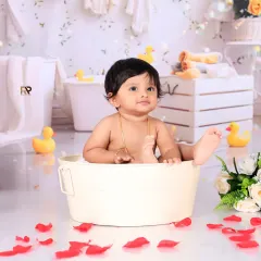 This little one is having a great time during a splash session, surrounded by bubbles and rubber ducks. The pure joy on his face is what makes these photos so special.