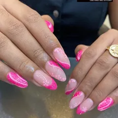 A vibrant and playful take on the French manicure. This design uses a bright pink glitter for the tips and accent nails, complemented by subtle, hand-painted cherry blossom art on a natural base.