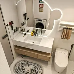 A fun and functional family bathroom with a Mickey Mouse-shaped backlit mirror and a well-organized vanity area.