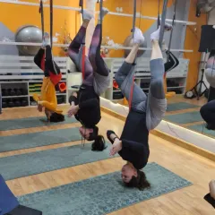 Flipping your perspective is one of the best parts of aerial yoga. This group inversion pose isn't just a cool photo opportunity; it's a form of aerial inversion therapy that helps decompress the spine, improve circulation, and gives you a natural rush of energy.