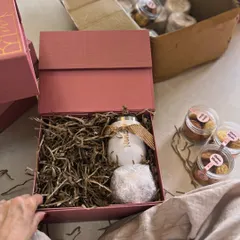 Behind the scenes of a book launch PR kit. This image shows the process of packing a custom bauble and other themed items into a personalized box, ensuring every element aligns with the book's narrative.