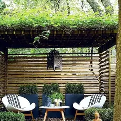 This cozy outdoor nook demonstrates how we create a Zen-inspired seating area. The design uses a natural bamboo pergola for shade, a slatted screen for privacy, and a meditating Buddha statue to establish a peaceful, reflective atmosphere perfect for unwinding.