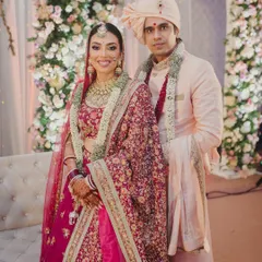 The perfect couple portrait. Her traditional bridal makeup, with its kohl-defined eyes and red lehenga, stands out beautifully, ensuring she is the star of the show.